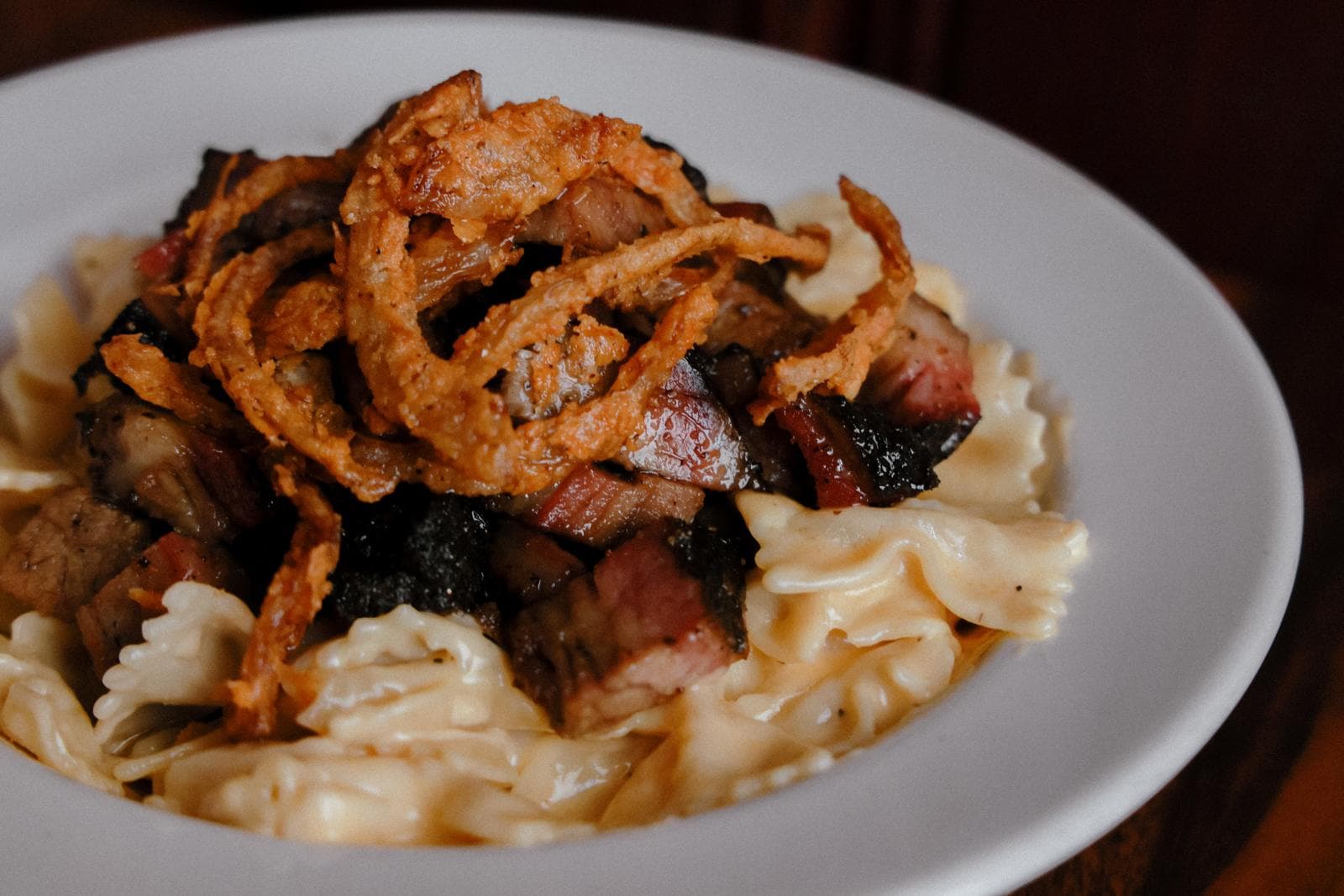 Brisket mac and cheese topped with fried onion strings